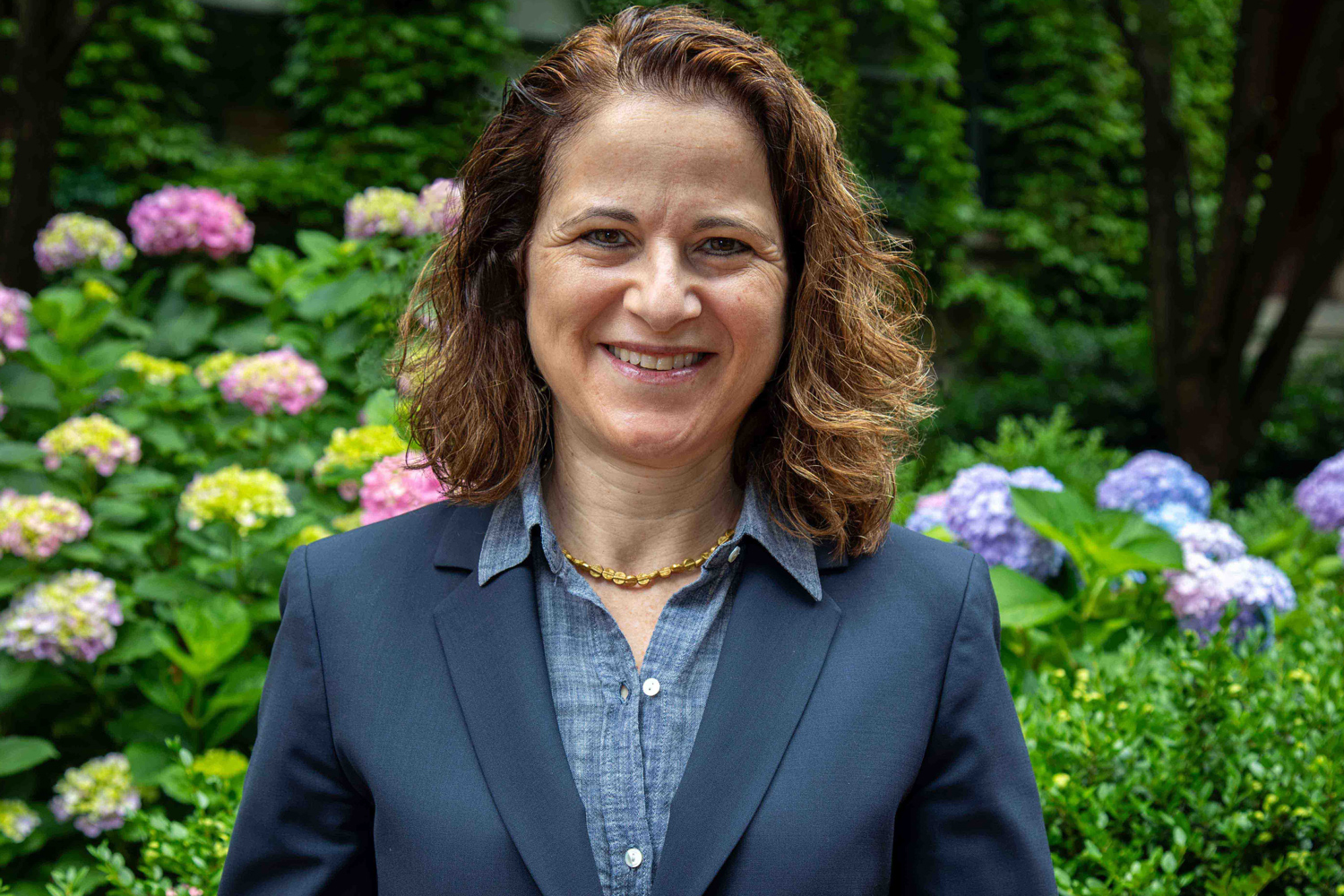 Photo of Provost Rebecca L. Walkowitz in front of hydrangeas